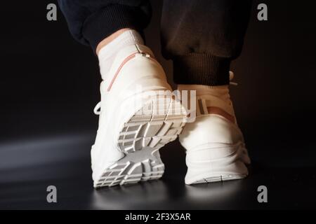 Un ensemble de baskets blanches pour femme à la salle de gym pour femme gros plan sur fond noir. Banque D'Images