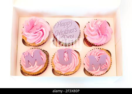 Une boîte de sélection de gâteaux de la tasse de fête des mères six en nombre avec Happy Mothers day sur l'un des gâteaux et MOM inscrit sur chacun des gâteaux. Banque D'Images