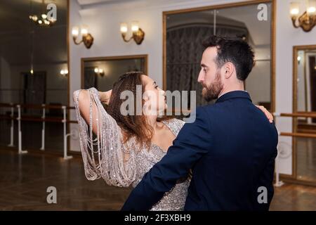 couple adulte dansant partenaire expressif dansant dans la salle de bal vide Banque D'Images