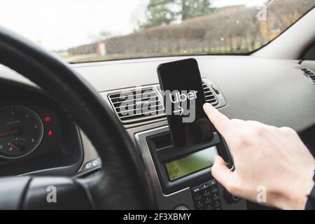 Uber atcs comme un pont pour connecter les conducteurs et les cavaliers. Il fournit le service de partage de parcours peer-to-peer pour les personnes qui veulent être un conducteur et ceux W Banque D'Images