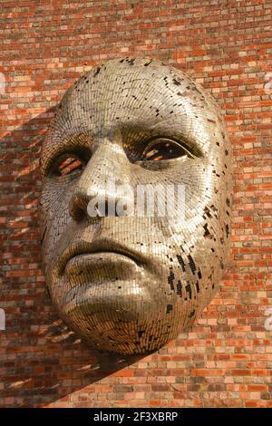 Sculpture métallique, face géante. Public Art à Lincoln City, à l'extérieur du lieu appelé The Drill Hall, Rick Kirby, acier inoxydable, petites bandes de métal. Banque D'Images