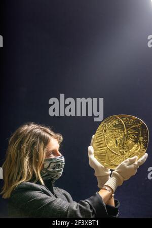 Un employé de Bonhams détient 'visage de Faune', une repoussŽ plaque d'or de 22 carats produite par Pablo Picasso et le forgeron Franois Hugo qui a une estimation de £250,000-350,000 lors d'un appel photo à Bonhams à Londres, avant leur prochaine vente de Picassomania, qui aura lieu le 23 mars. Date de la photo: Jeudi 18 mars 2021. Banque D'Images