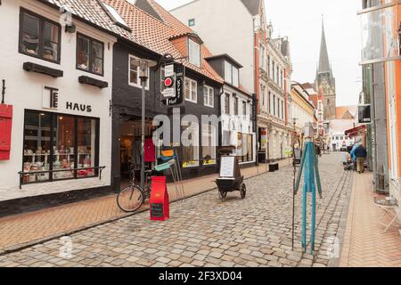 Flensburg, Allemagne - 9 février 2017 : vue sur la rue de la vieille ville de Flensburg, Allemagne. Les gens ordinaires marchent dans la rue près des magasins locaux Banque D'Images