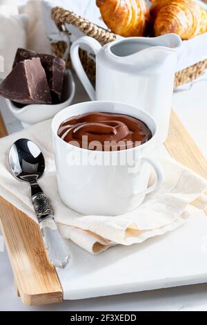 Petit déjeuner appétissant avec une délicieuse tasse de chocolat chaud épais et buvable, ainsi que des croissants. Style maison. Banque D'Images