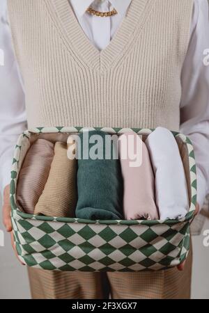 Rangement vertical des vêtements dans un récipient. Dans les mains d'une femme Banque D'Images