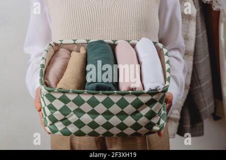 Rangement vertical des vêtements dans un récipient. Dans les mains d'une femme Banque D'Images