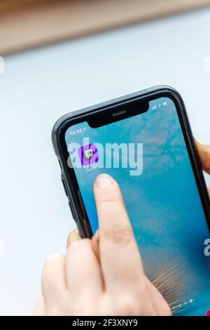 Paris, France - Marsh 18, 2021 : Jeune femme utilisant l'application Twitch sur son smartphone Banque D'Images