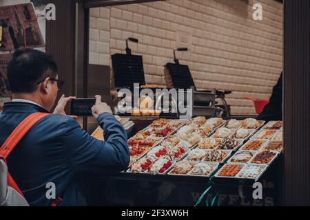 Bruxelles, Belgique - 16 août 2019 : variété de gaufres belges traditionnelles avec différentes garnitures en vente dans un magasin à Bruxelles, touriste prenant un ph Banque D'Images