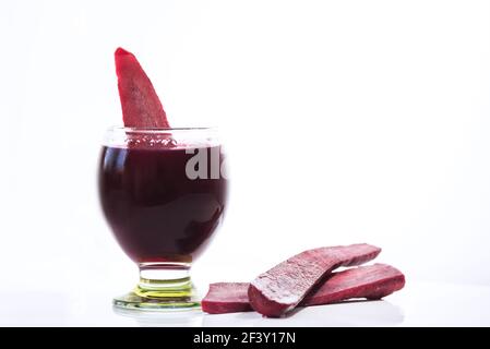 Un verre de jus de navet fermenté traditionnel appelé 'Şalgam' avec des carottes rouges sur fond blanc, en gros plan, isolé Banque D'Images