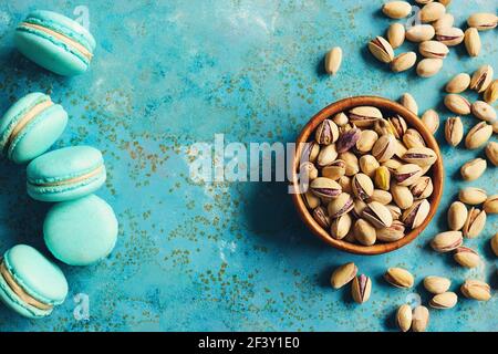 Pistaches dans un bol et macarons aromatisés au pistache Banque D'Images