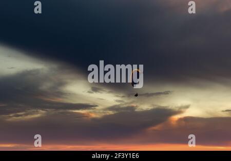 Parapente volant dans le beau ciel contre le fond des nuages. Banque D'Images