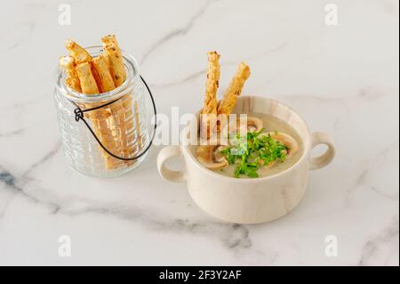 Soupe à la crème aux champignons avec croûtons, herbes et épices sur fond de marbre. Banque D'Images