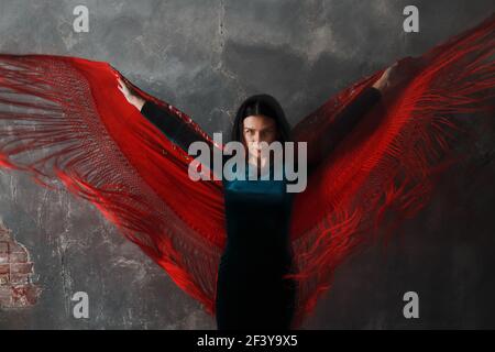 Jeune danseuse adulte dansant le flamenco sur fond gris vintage. Banque D'Images