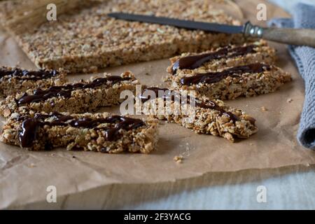 Vue rapprochée d'une barre de muesli fraîche et maison sans cuisson avec noix, sésame, sucettes d'amaranth et avoine soufflée. Fait avec du miel et du sirop d'érable Banque D'Images