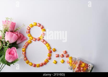 un bouquet de roses sur fond blanc avec des couleurs vives bonbons dans un pot Banque D'Images