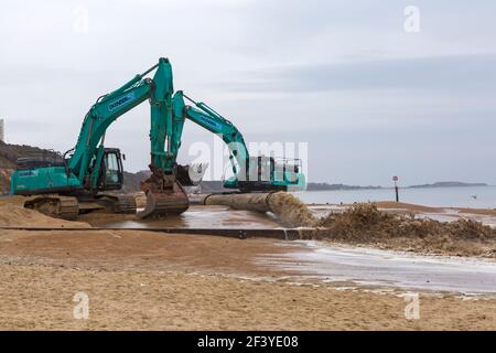 Bournemouth, Dorset, Royaume-Uni. 18 mars 2021. Les travaux de réapprovisionnement de la plage ont lieu sur la plage de Bournemouth, le sable étant pompé hors de la mer par une drague à travers des tuyaux sur le bord de mer de la plage. Avec plus de personnes susceptibles de prendre des promenades cette année et des vacances à Bournemouth les plages de sable doré font partie de l'attraction. Excavatrices Ovenden SK500 - l'eau et le sable sont pompés et se précipitent. Crédit : Carolyn Jenkins/Alay Live News Banque D'Images