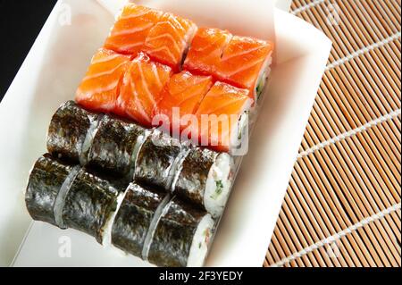 Gros plan des petits pains maki à sushi et des nigiri avec des crevettes sur la boîte écologique de recyclage à emporter. Concept de livraison de nourriture. Déjeuner sur l'espace de travail. Banque D'Images