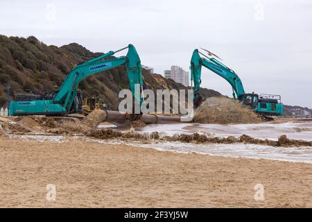 Bournemouth, Dorset, Royaume-Uni. 18 mars 2021. Les travaux de réapprovisionnement de la plage ont lieu sur la plage de Bournemouth, le sable étant pompé hors de la mer par une drague à travers des tuyaux sur le bord de mer de la plage. Avec plus de personnes susceptibles de prendre des promenades cette année et des vacances à Bournemouth les plages de sable doré font partie de l'attraction. Excavatrices Ovenden SK500 - l'eau et le sable sont pompés et se précipitent. Crédit : Carolyn Jenkins/Alay Live News Banque D'Images