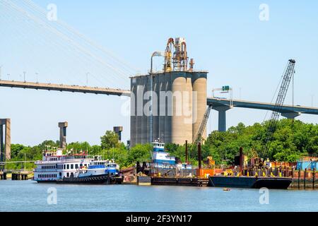 Savannah, États-Unis - 11 mai 2018 : bord de mer de la rivière Savannah avec Georgia Queen traversier en bateau à vapeur par des silos industriels en béton stockage pour le ciment dans le sud Banque D'Images