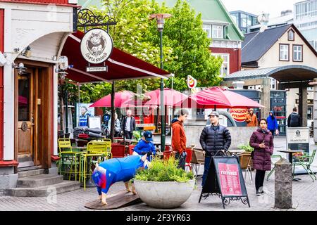 Reykjavik, Islande - 19 juin 2018 : trottoir de rue coloré dans le centre-ville et panneaux pour le gastéropub cochon et les gens Banque D'Images