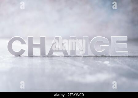Mot de changement de mot fait avec des lettres de ciment sur fond de marbre gris. Copier l'espace. Concept Banque D'Images