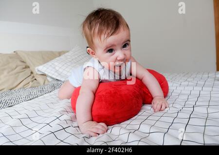 Happy baby girl, cinq mois, sur le lit Banque D'Images