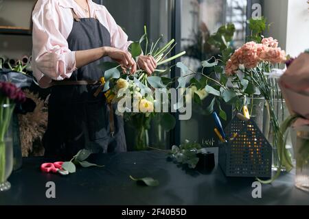 Photo d'un fleuriste tenant de belles fleurs dans un magasin de fleurs, espace de copie. Boutique de fleurs Lifestyle. Belle composition florale Banque D'Images