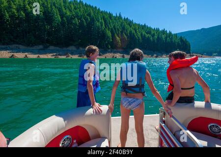 Frères et sœurs dans un bateau patio sur un lac Banque D'Images