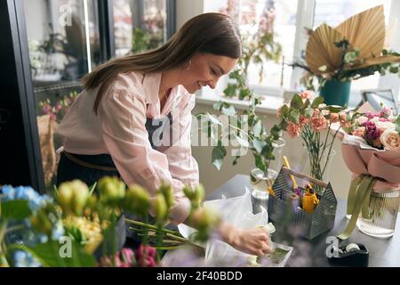 Jardinier s dans la boutique de fleurs faire un bouquet pour des vacances. Boutique de fleurs Lifestyle. Belle composition florale. Détails. Gros plan Banque D'Images