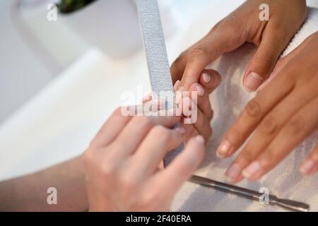 Soins des ongles manucure pour le client assis à une table dans le bureau. Les concepts esthétiques et de beauté. Banque D'Images