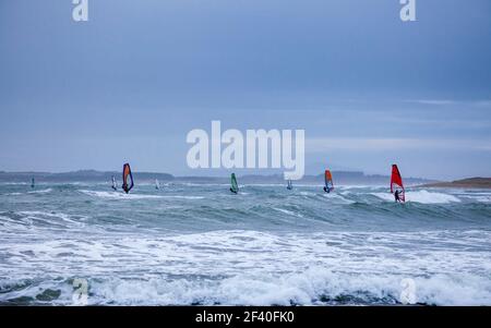 Planches à voile pendant une tempête d'hiver sur la plage de Rhosneigr, Anglesey, pays de Galles Banque D'Images