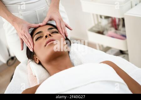 Femme arabe recevoir head massage in spa centre de bien-être. Les concepts esthétiques et de beauté. Banque D'Images