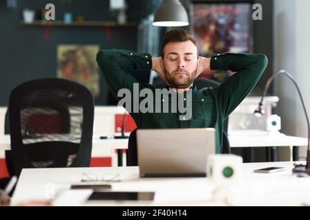 Jeune homme étudiant avec un ordinateur portable sur blanc 24. Guy attrayants avec des tenues de porter la barbe en faisant une pause. Banque D'Images