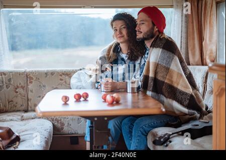 Couple assis à une table dans un camping-car et de boire du thé. Banque D'Images