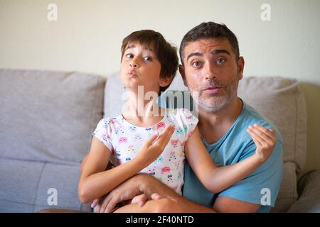 Petite fille mignonne qui fait le maquillage de son père. Papa passe du temps libre avec sa fille. Concept de masculinité alternative.. Petite fille mignonne qui fait le maquillage de son père Banque D'Images