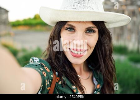 Belle jeune femme de randonnée, portant une chemise fleurie, prenant une photo de selfie à l'extérieur. Une jeune femme de randonnée prend une photo de selfie à l'extérieur Banque D'Images