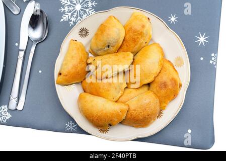 Boulettes dorées cuites dans une tarte posée sur une table de vacances sur une assiette, isolée sur un fond blanc avec un chemin d'écrêtage, vue du dessus. Banque D'Images