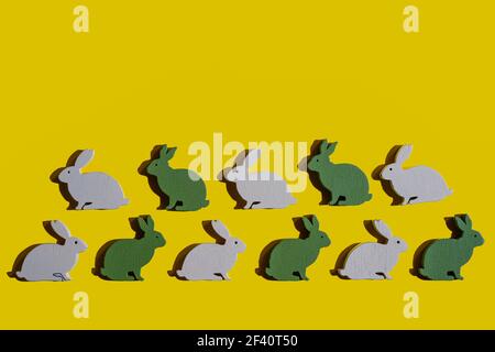 Quelques lapins en bois de Pâques sur une surface jaune Banque D'Images