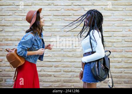 Deux amis qui s'amusent dans la rue. Femmes multiethniques.. Deux amies qui s'amusent ensemble dans la rue. Amis multiethniques. Banque D'Images