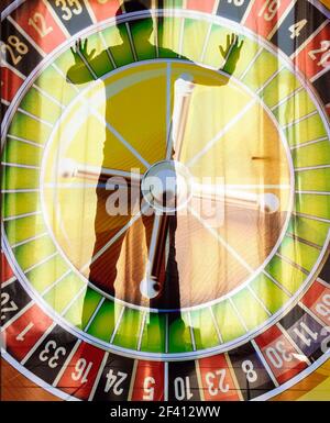 Vue arrière de l'homme mûr regardant hors de la fenêtre avec roulette surmontée. Jeu, dépendance de jeu, santé mentale, dette... concept Banque D'Images