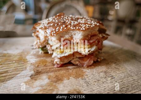 Bited Fresh Delicious Burger sur la plaque de bois vue latérale avec copyspace sur le premier plan. Bited Fresh Delicious Burger sur la plaque de bois vue latérale. Banque D'Images