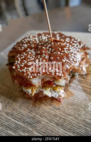 Bited Fresh Delicious Burger sur la plaque en bois au-dessus de la vue avec copyspace au premier plan. Délicieux hamburger frais sur la plaque en bois au-dessus de la vue, espace de copie Banque D'Images