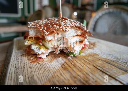 Bited Burger sur une assiette en bois. Hamburger sur une assiette en bois. Banque D'Images