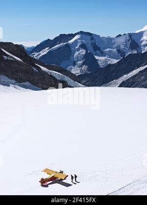 Suisse Jungfraujoch-Haut de l'Europe. Avion sur glacier avec montagnes en arrière-plan et deux personnes à pied. Le Grand glacier d'Aletsch, à 2 Banque D'Images