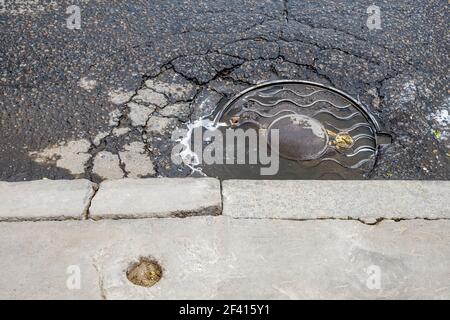 Trous d'égout sur la chaussée asphaltée. Couverture de vidange de trou d'homme dans les rues de Moskow Russie. Couverture de vidange de trou d'homme dans les rues de Moskow Russie. Banque D'Images