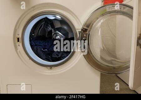 Ouvrez le lave-linge avec quelques vêtements à l'intérieur du tambour Banque D'Images