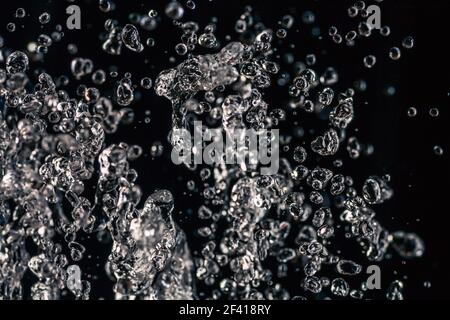 De nombreuses gouttes d'eau congelées dans un air sur fond sombre, concept d'eau. De nombreuses gouttes d'eau congelées dans un air sur fond sombre Banque D'Images