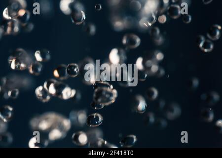 Petites gouttes d'eau gelées dans un air sur fond bleu foncé. Petites gouttes d'eau congelées dans un air bleu foncé Banque D'Images