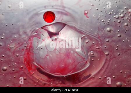 Gouttes d'eau colorées, ondulations circulaires, éclaboussures d'eau, gros plan. Banque D'Images