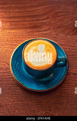 Au-dessus de la vue de la tasse à cappuccino sur la table avec latte art sur la mousse supérieure, l'image est prise avec copyspace. Vue au-dessus de la tasse à cappuccino sur la table avec latte art sur le dessus Banque D'Images